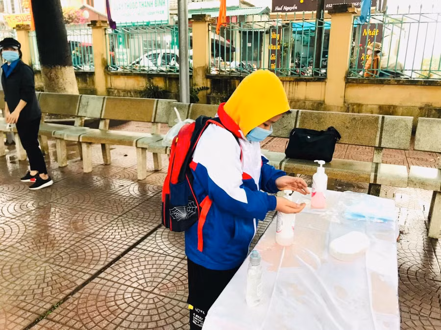 Học sinh đến trường chủ động rửa tay bằng nước sát khuẩn phòng dịch Covid-19.