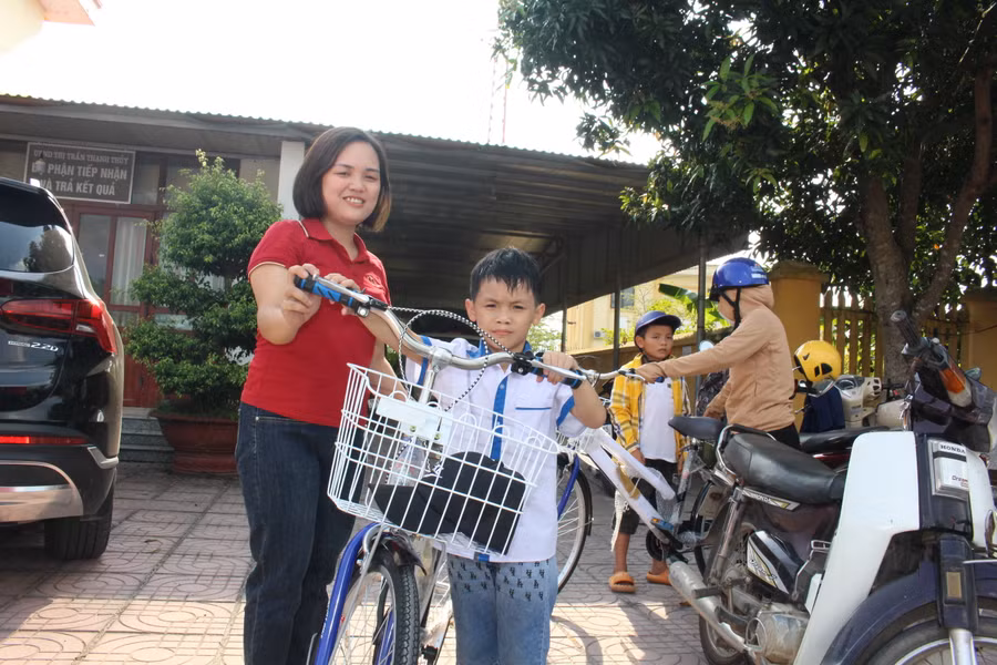 Nguyễn Tuấn Ngọc cùng mẹ trong niềm vui nhận xe đạp mới.