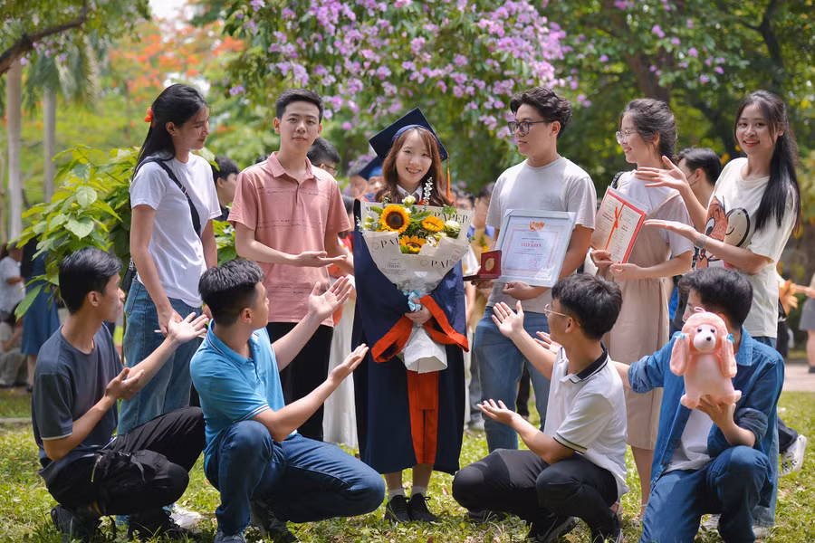Bùi Thị Thuỳ (thứ ba từ trái sang, hàng 2) được các bạn đến chúc mừng trong lễ tốt nghiệp.