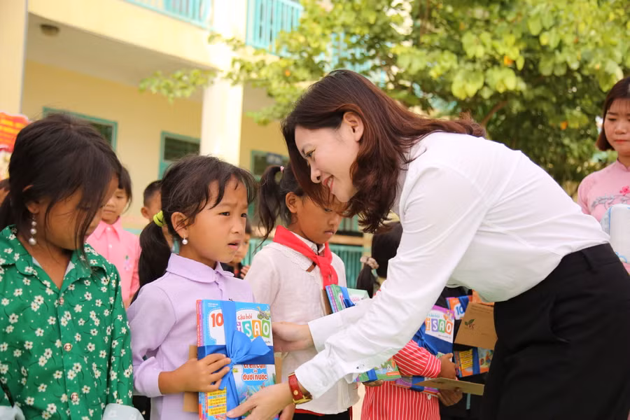 Chị Đỗ Thị Kim Hoa, giám đốc Trung tâm Tình nguyện quốc gia, tặng quà cho học sinh năm học mới.