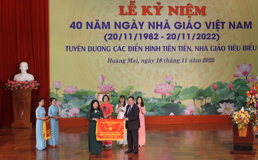 Lãnh đạo quận Hoàng Mai tặng cờ thi đua của Chủ tịch UBND TP cho các đơn vị.