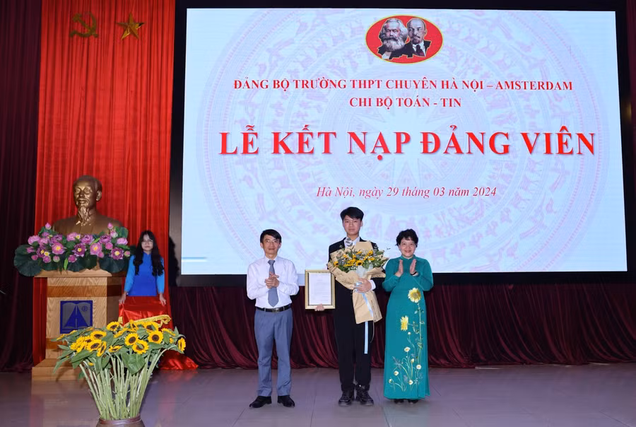 Bí thư Đảng bộ Trường THPT chuyên Hà Nội - Amsterdam Trần Thủy Dương và đại diện Quận ủy Cầu Giấy trao quyết định kết nạp Đảng cho học sinh Đặng Nguyễn Đức Huy.