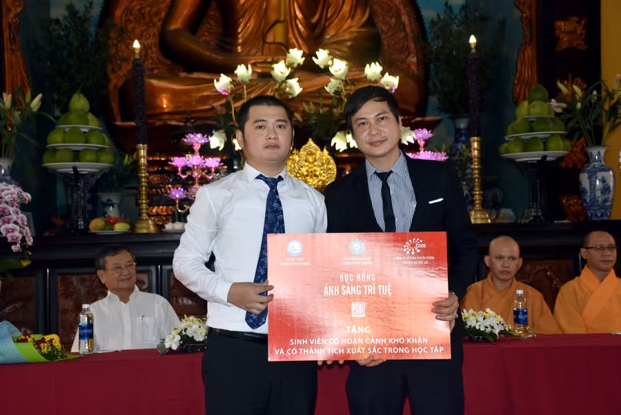 Ông Nguyễn Đoàn Anh Khoa (trái) trao biểu trưng học bổng cho đại diện Trường ĐH Y Dược TPHCM