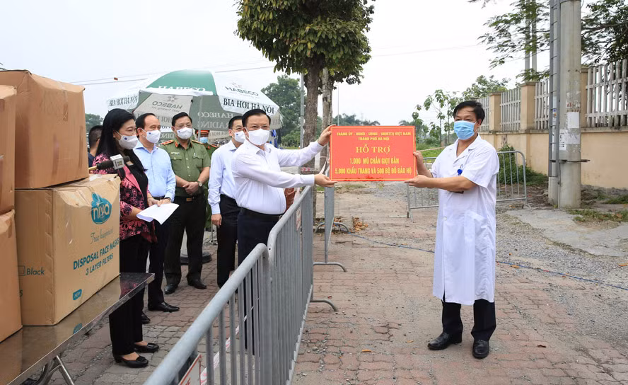 Bí thư Thành ủy Hà Nội Đinh Tiến Dũng trao tặng hỗ trợ của thành phố cho y, bác sĩ Bệnh viện Bệnh nhiệt đới trung ương cơ sở 2, tại huyện Đông Anh.
