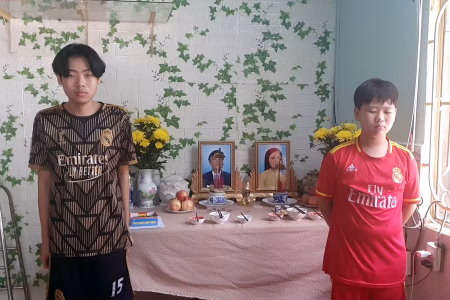 Hai anh em Phan Tuấn Kiệt và Phan Gia Lạc (TX Thuận An, Bình Dương) đứng trước di ảnh ba mẹ.