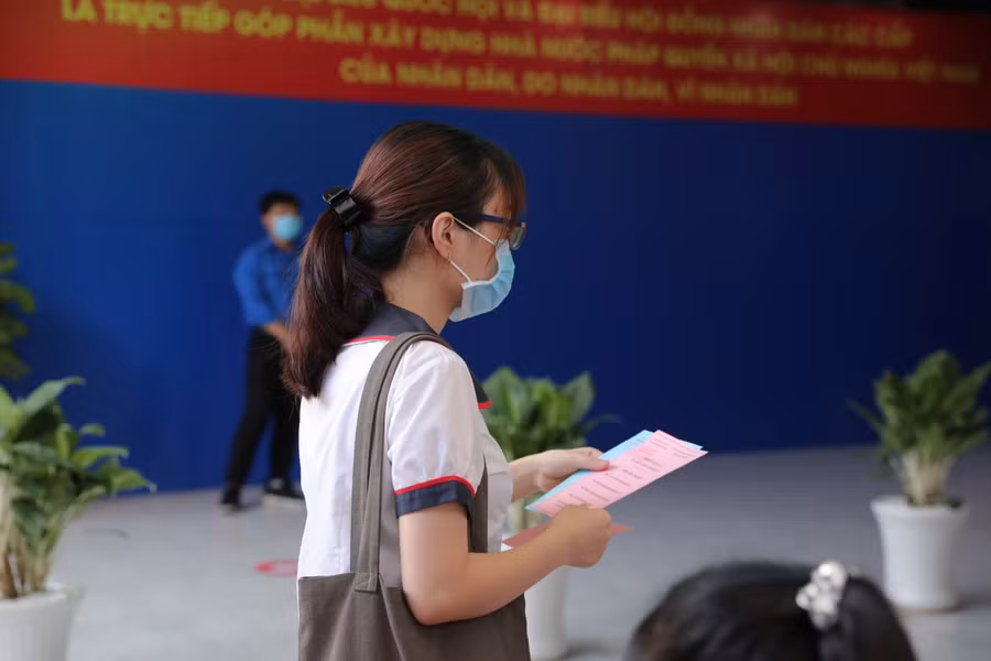 SV Trường ĐH Công nghiệp TPHCM với thẻ cử tri trên tay đi tới điểm bỏ phiếu.