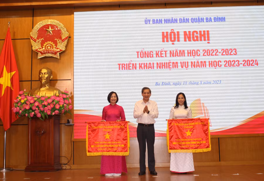 Thừa ủy quyền, ông Hoàng Minh Dũng Tiến - Bí thư Quận ủy Ba Đình trao Cờ thi đua của UBND TP Hà Nội cho hai tập thể.