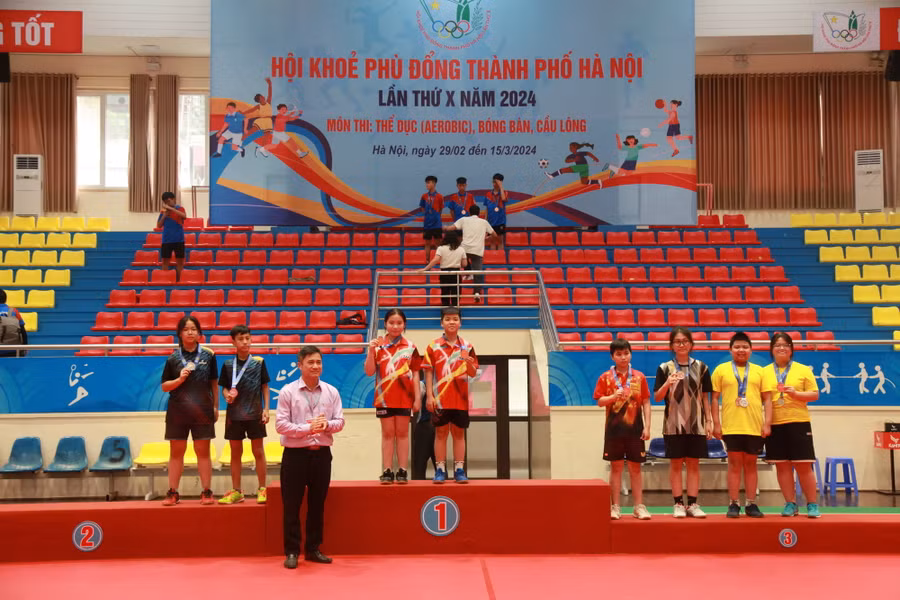 Ông Kiều Cao Trinh - Phó trưởng Phòng Chính trị tư tưởng, Khoa học Công nghệ (Sở GD&ĐT Hà Nội) trao huy chương cho các VĐV đoạt Huy chương Vàng nội dung đôi nam, nữ lứa tuổi THCS.