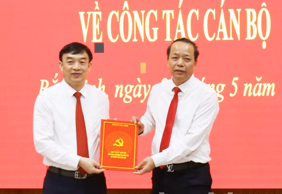 Phó Bí thư Thường trực Tỉnh ủy, Chủ tịch HĐND tỉnh Bắc Ninh Nguyễn Quốc Chung (phải) trao Quyết định cho ông Nguyễn Đình Lợi.