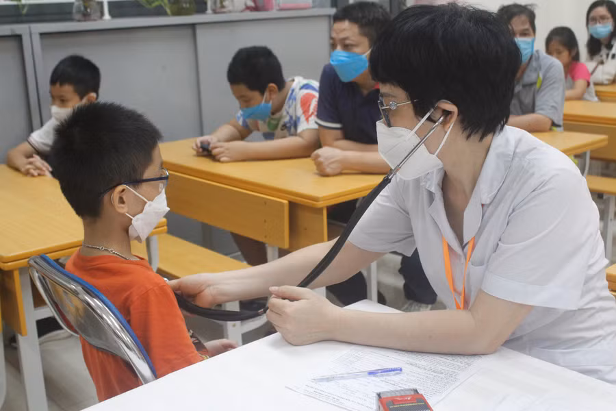 Khám sàng lọc cho học sinh trước khi tiêm.