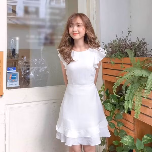 Chiếc váy trắng có phần vai bèo tạo sự nữ tính, duyên dáng cho các cô gái.