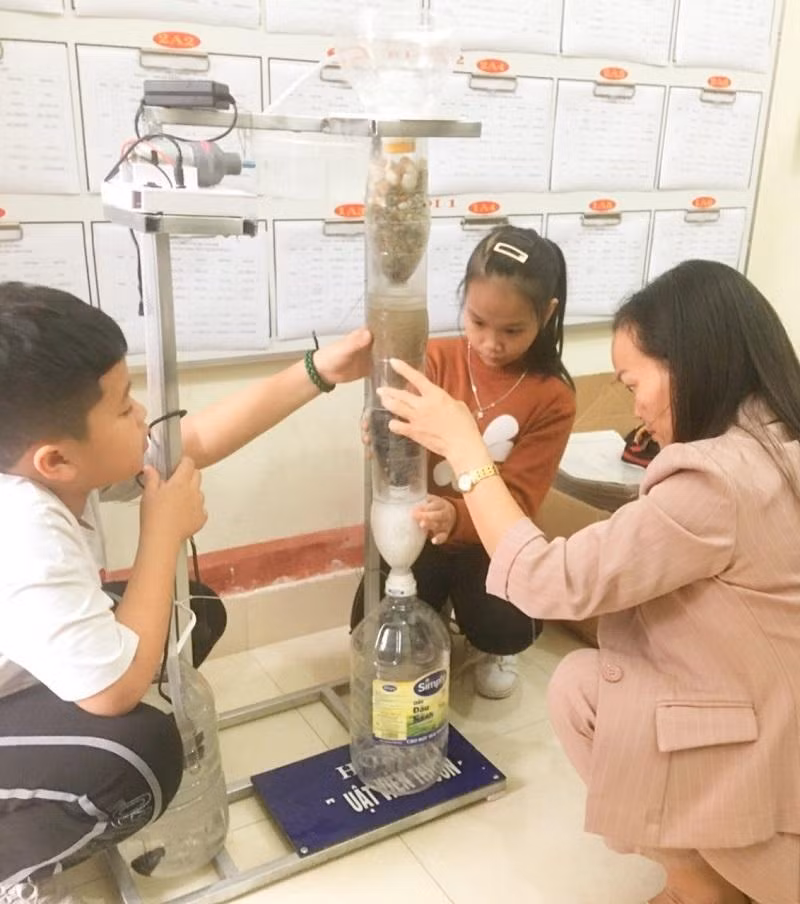 Cô Thơm cùng học sinh nghiên cứu làm máy lọc nước. Ảnh NVCC.