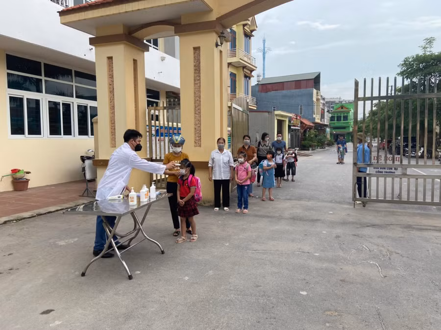Học sinh được phụ huynh đưa đến tựu trường, đo thân nhiệt, xếp hàng phòng dịch.