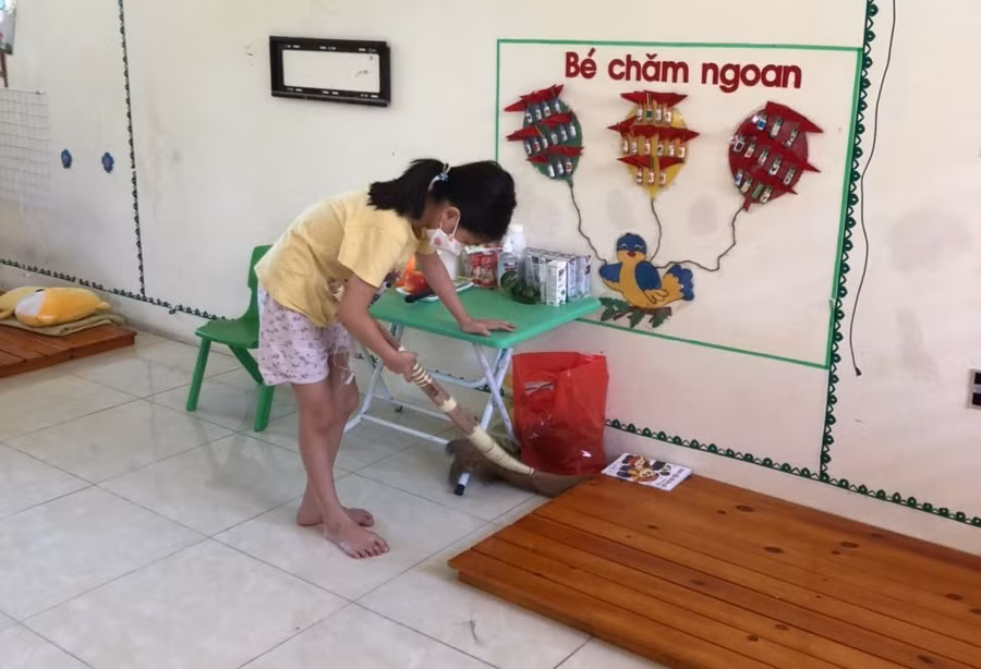 Một học sinh tranh thủ dọn dẹp vệ sinh trong phòng tại khu cách ly.