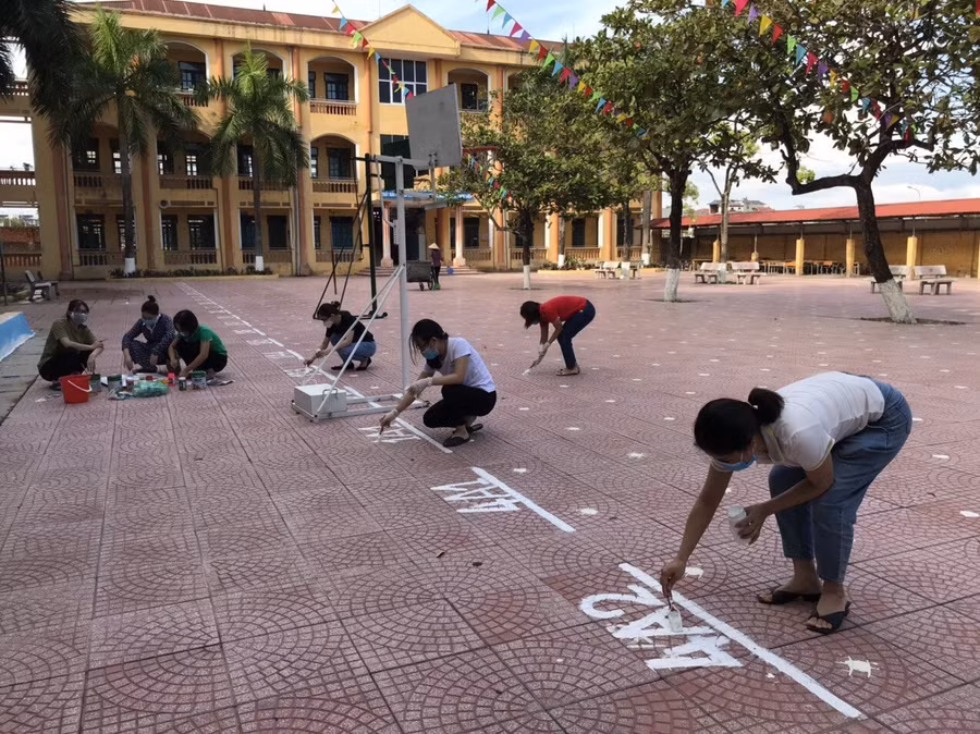 Cô giáo Trường Tiểu học Nam Hồng tổ chức vệ sinh trường lớp, thực hiện kẻ vạch hướng dẫn học sinh.