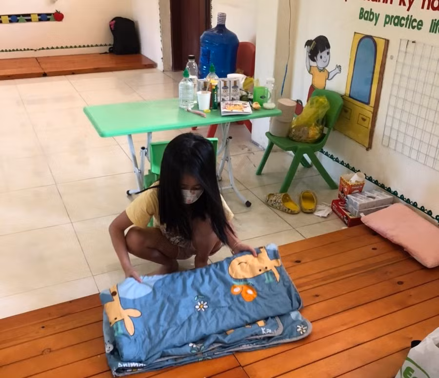 Học sinh tự gấp đồ dùng sau khi thức dậy trong khu cách ly.