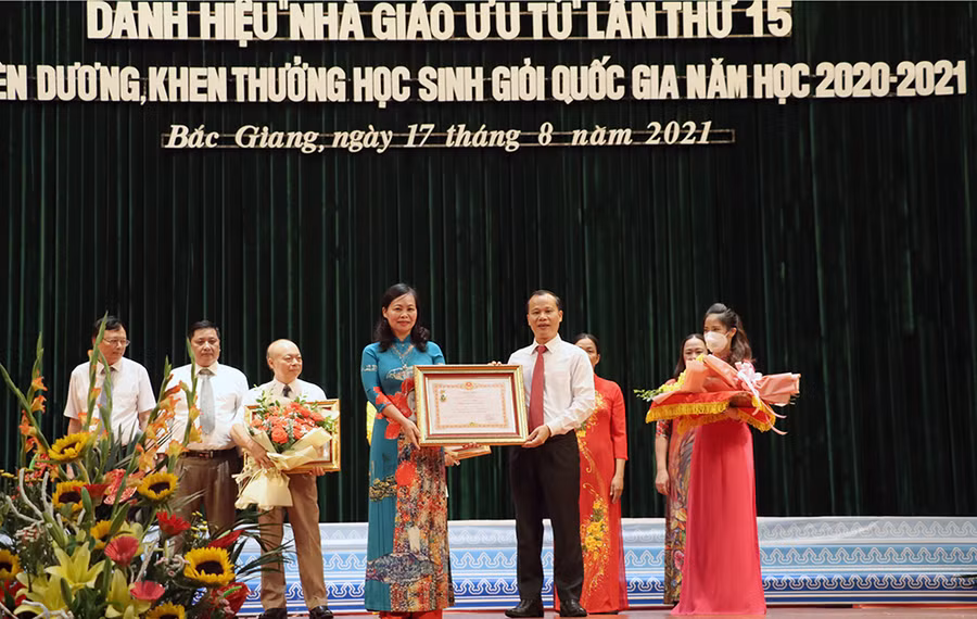 Ông Mai Sơn - Phó Chủ tịch UBND tỉnh Bắc Giang thừa ủy quyền Chủ tịch nước trao tặng Danh hiệu "Nhà giáo ưu tú" cho nhà giáo Trần Thúy Hoàn.