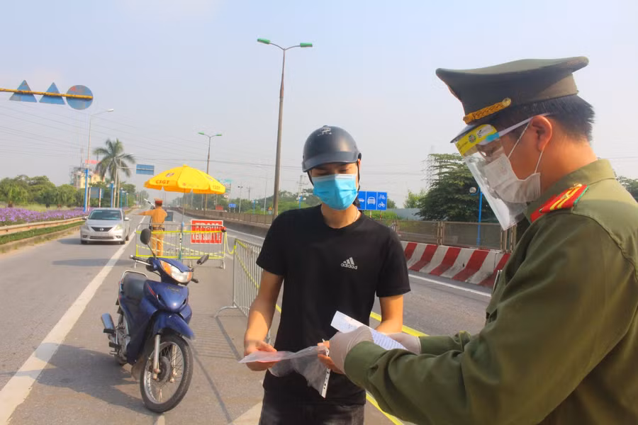 Người dân xuất trình giấy đi đường qua các chốt kiểm soát phòng dịch.