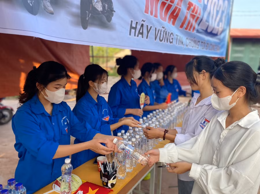 Thí sinh vui mừng đón nhận chai nước từ tình nguyện viên.