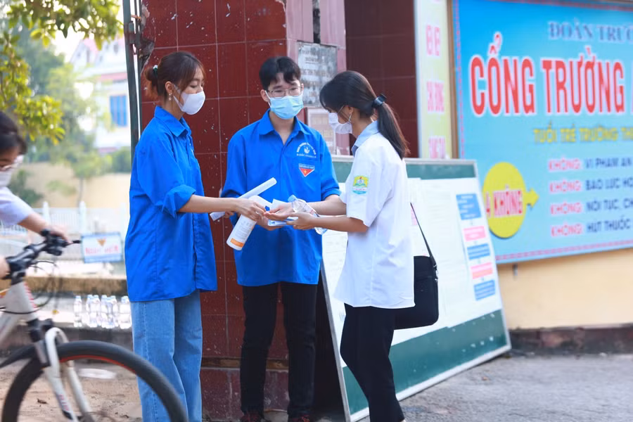 Thanh niên tình nguyện tặng nước uống, nhắc nhở thí sát khuẩn tay phòng dịch Covid-19.