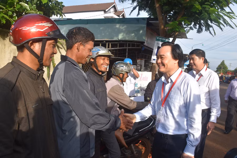 Bộ trưởng Phùng Xuân Nhạ thăm hỏi động viên phụ huynh (dân tộc Ê đê) đang chờ con bên ngoài