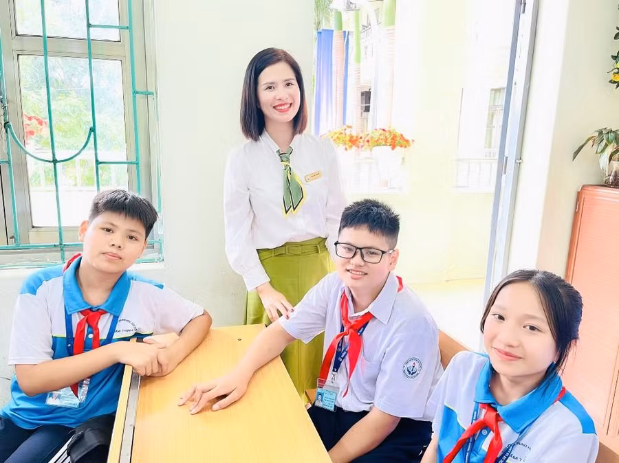 Em Chiến (áo trắng ở giữa) vui vẻ bên cô giáo và bạn bè.