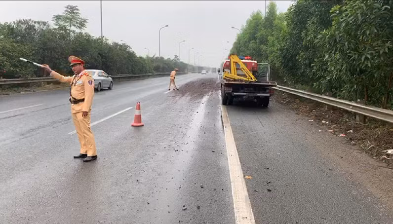 Cùng với việc phân luồng giao thông, tổ công tác của Đội CSGT số 11 đã mượn xẻng thu dọn đất đá đảm bảo an toàn giao thông.