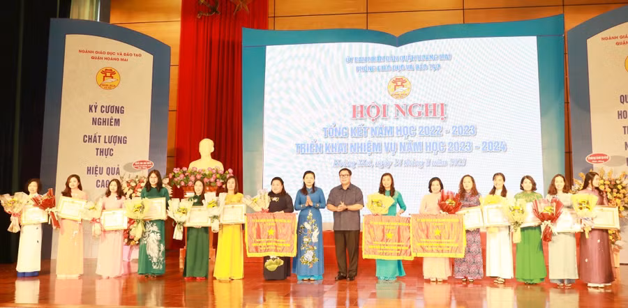 Bí thư Quận ủy Hoàng Mai Nguyễn Quang Hiếu, Phó Giám đốc Sở GD&ĐT Hà Nội Trần Lưu Hoa trao cờ thi đua cho các đơn vị.