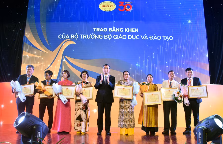 Thứ trưởng Bộ GD&amp;ĐT Nguyễn Văn Phúc trao bằng khen của Bộ trưởng Bộ GD&amp;ĐT cho đại diện các tập thể của HUFLIT.
