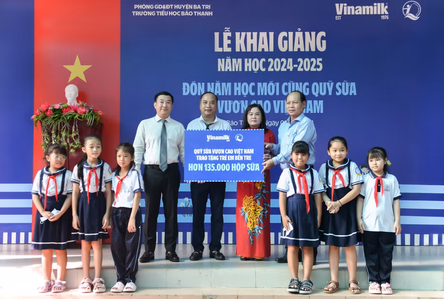 : Đại diện Vinamilk & Quỹ bảo trợ trẻ em Việt Nam (bên trái) trao bảng tượng trưng phần hỗ trợ hơn 135.000 hộp sữa cho đại diện Sở Lao động thương binh & xã hội tỉnh Bến Tre nhân ngày khai giảng 5/9