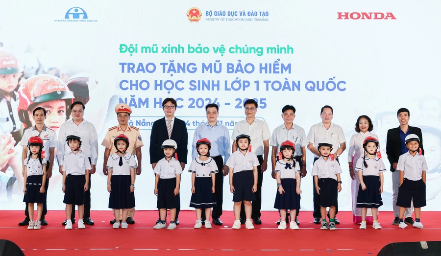 Các đại biểu trao tặng mũ bảo hiểm cho các em học sinh lớp 1 trường Tiểu học Tiểu La (quận Sơn Trà).