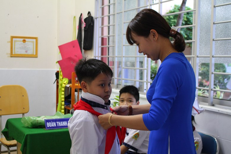 Cô thắt khăn quàng cho trò chuẩn bị khai giảng.