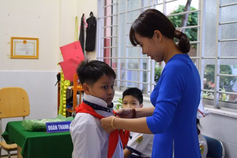 Cô thắt khăn quàng cho trò chuẩn bị khai giảng.