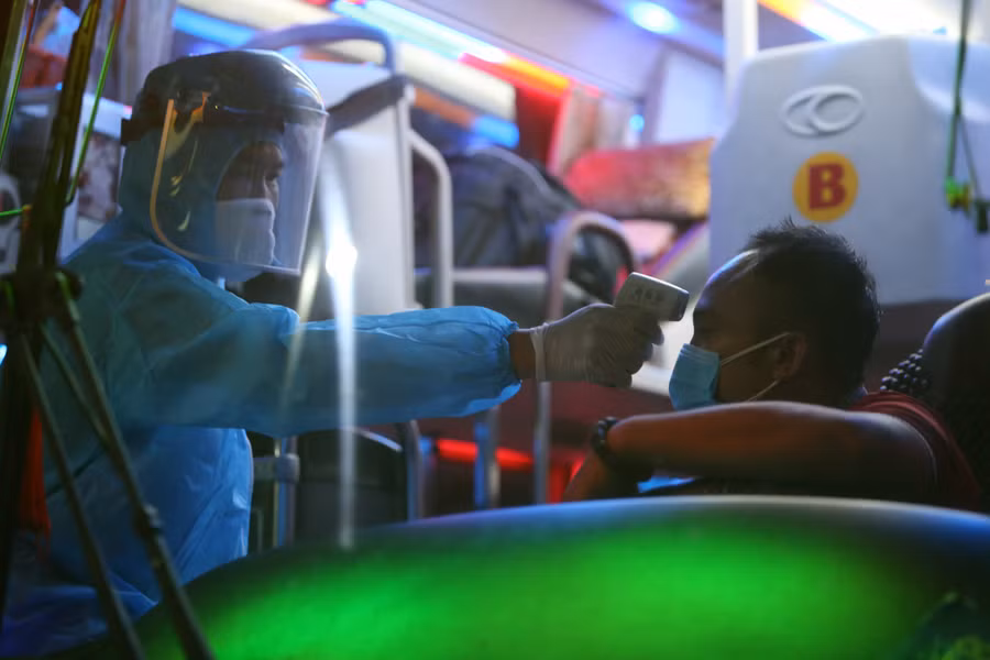 Cán bộ y tế trực tại chốt kiểm tra thân nhiệt các lái xe và hành khách đến từ các vùng dịch bệnh