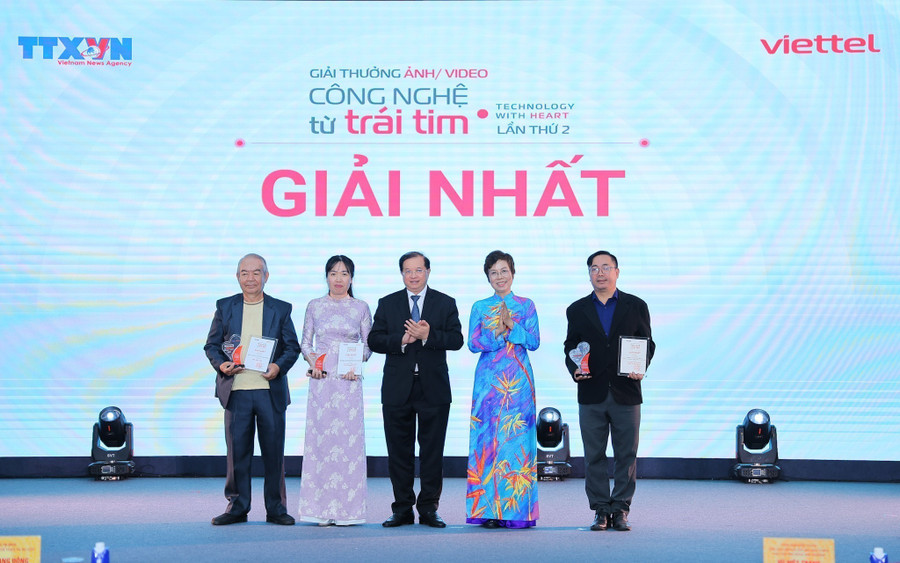 Tổng Giám đốc TTXVN Vũ Việt Trang, Chủ tịch Hội đồng Giải thưởng và Thứ trưởng Bộ Văn hóa, Thể thao và Du lịch Tạ Quang Đông trao giải Nhất cho các tác giả. (Ảnh: Lê Đông - TTXVN)