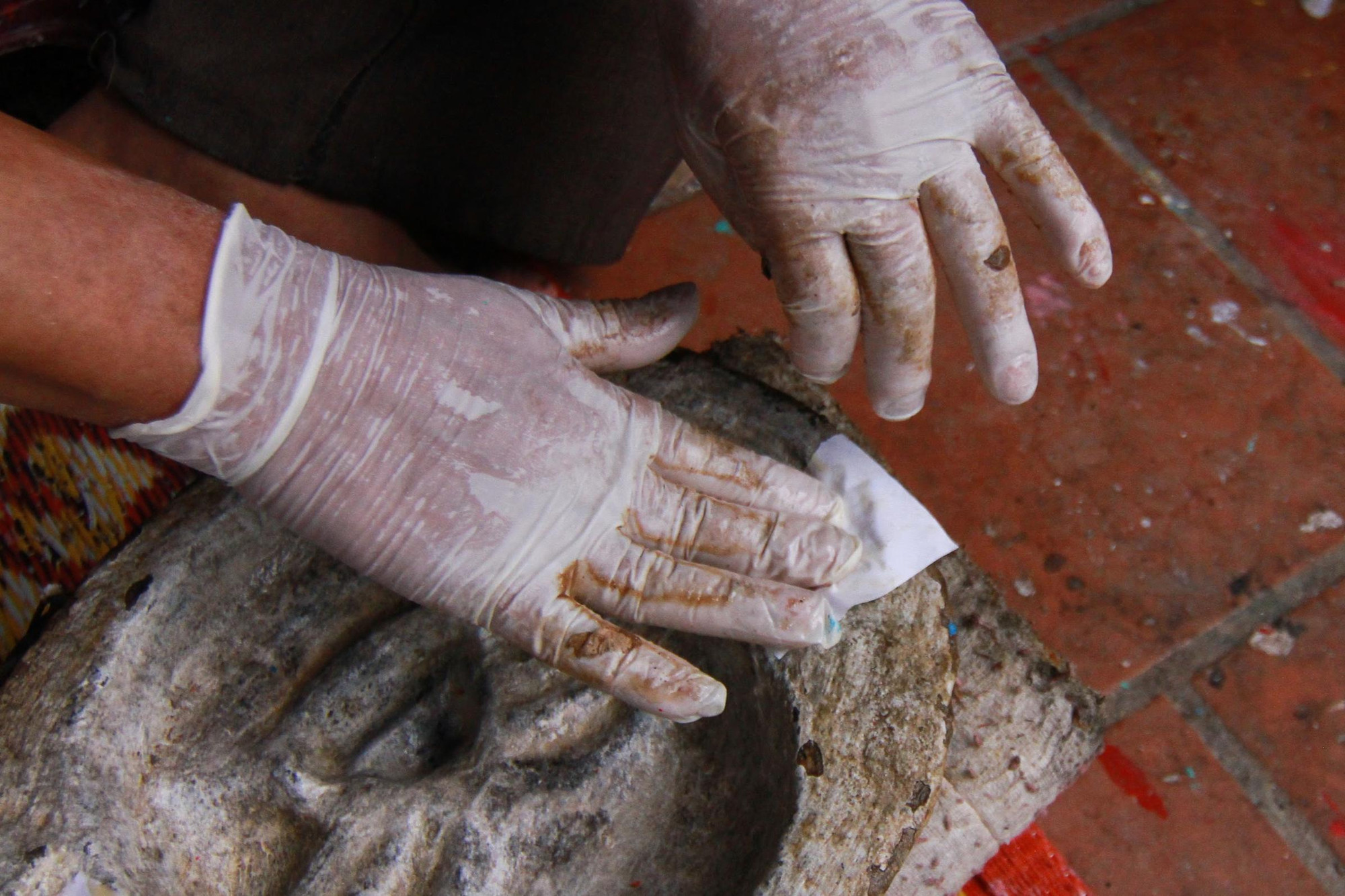 Những công đoạn đầu tiên là phải xé giấy thật nhỏ, sau đó lót một lớp giấy trắng vào khuôn xi măng đúc sẵn.