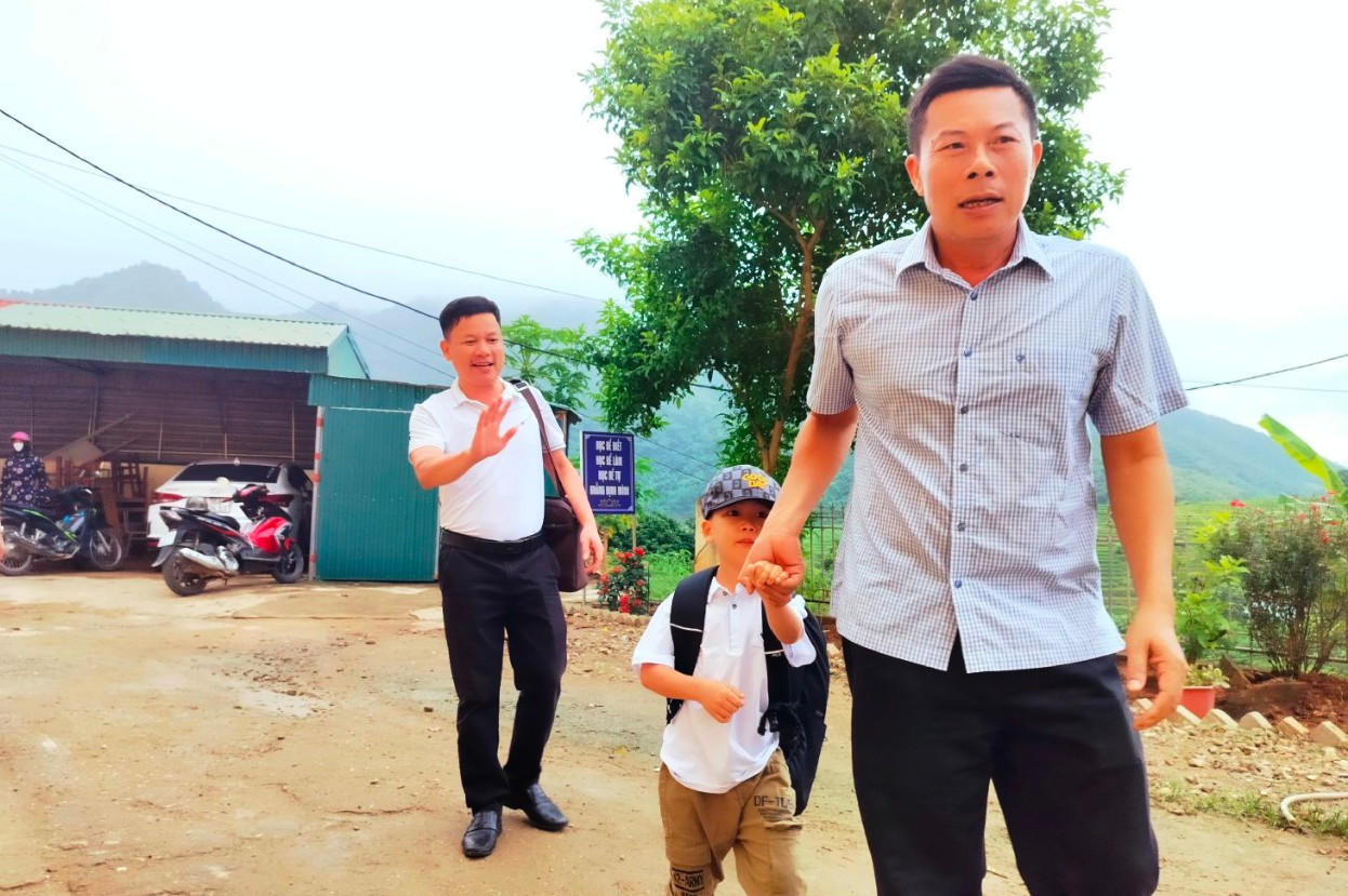 Thầy Nguyễn Văn Giang, Hiệu trưởng Trường TH&amp;THCS thị trấn Mường Lát (Thanh Hóa) đón học sinh lớp 1 trong buổi tựu trường. Ảnh: NTCC.