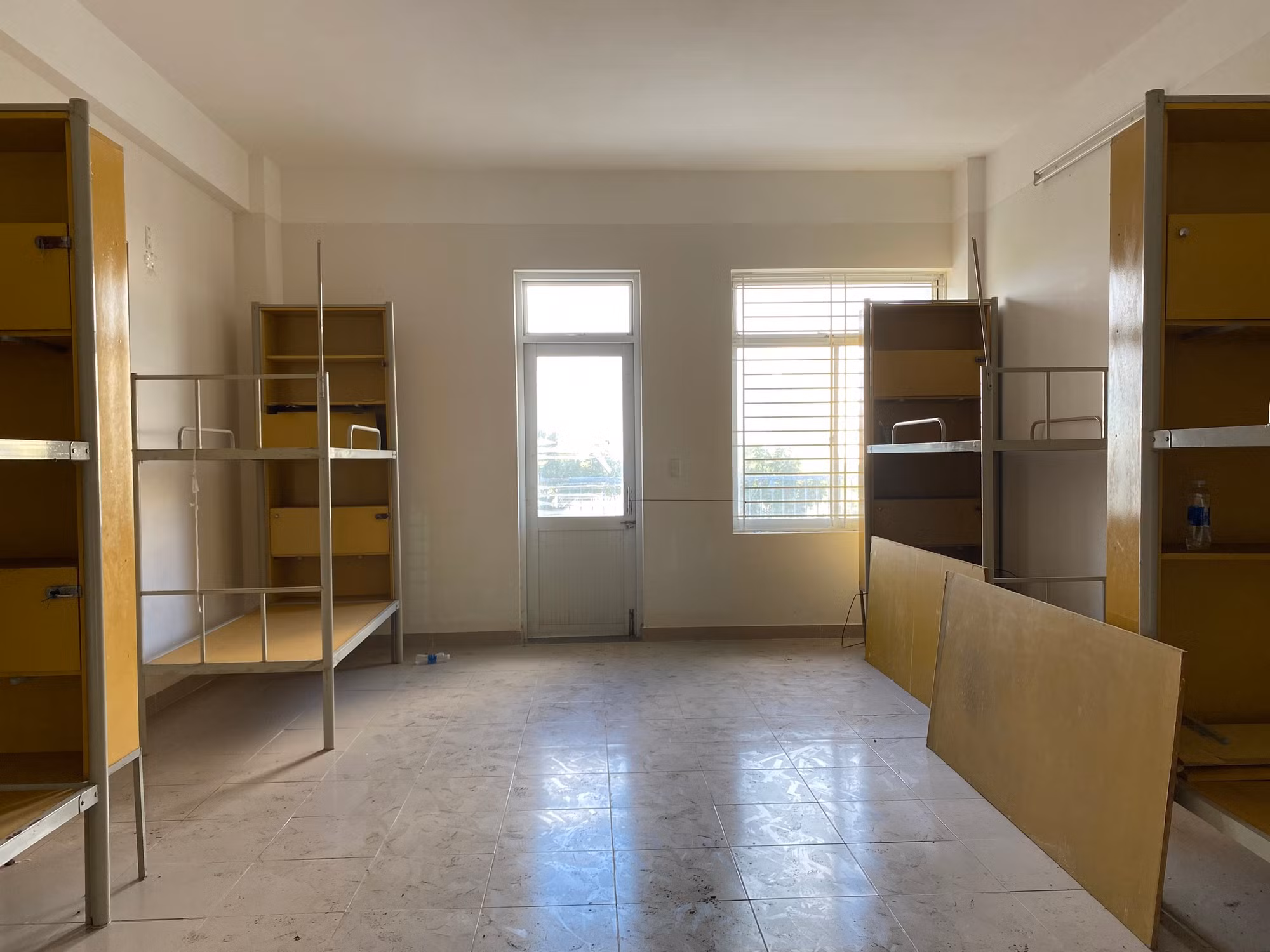 Bên trong phòng, lối đi và nhiều giường tầng bụi bám dày.