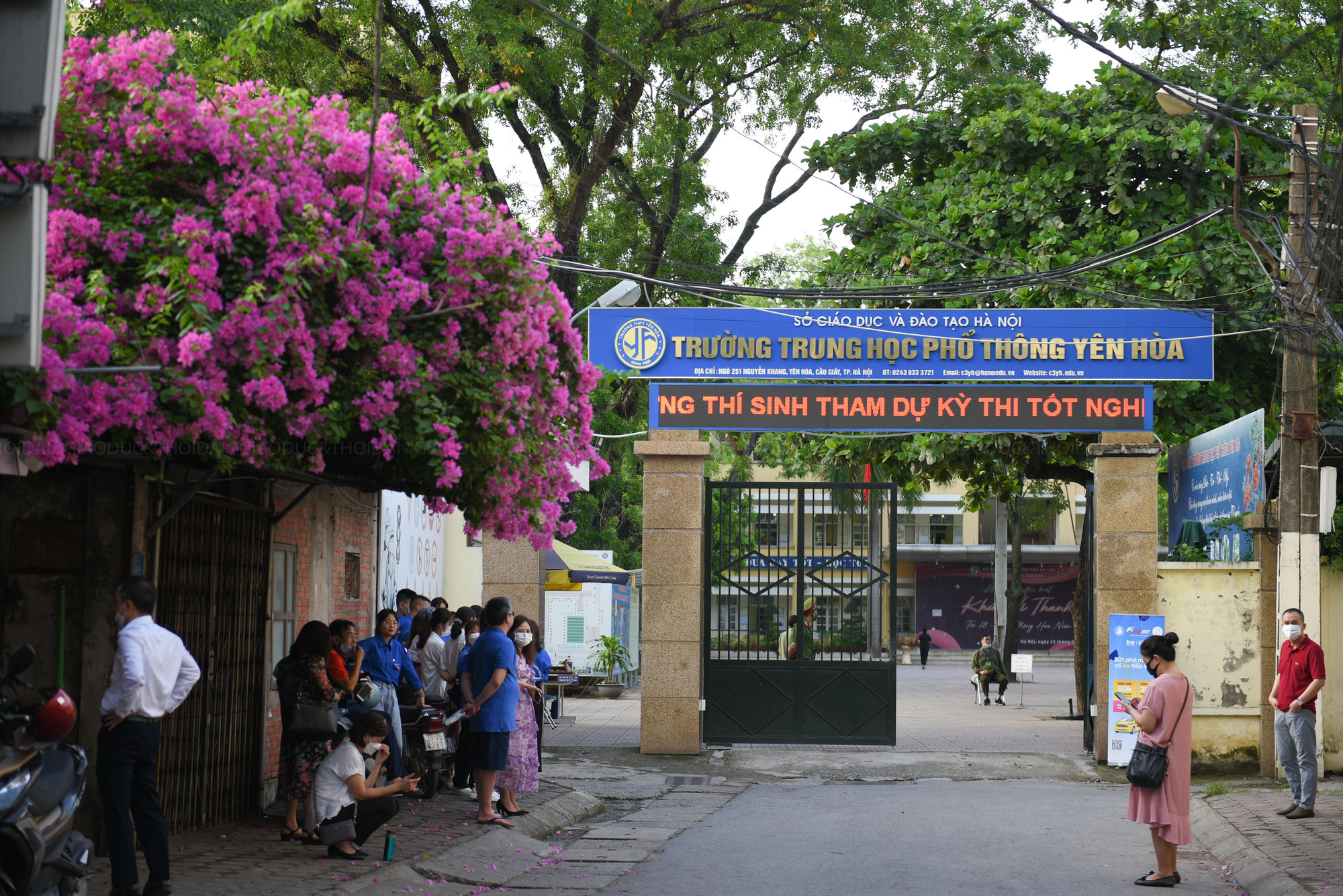 Phía bên ngoài phụ huynh lo lắng đứng đợi con em mình tại cổng điểm thi.