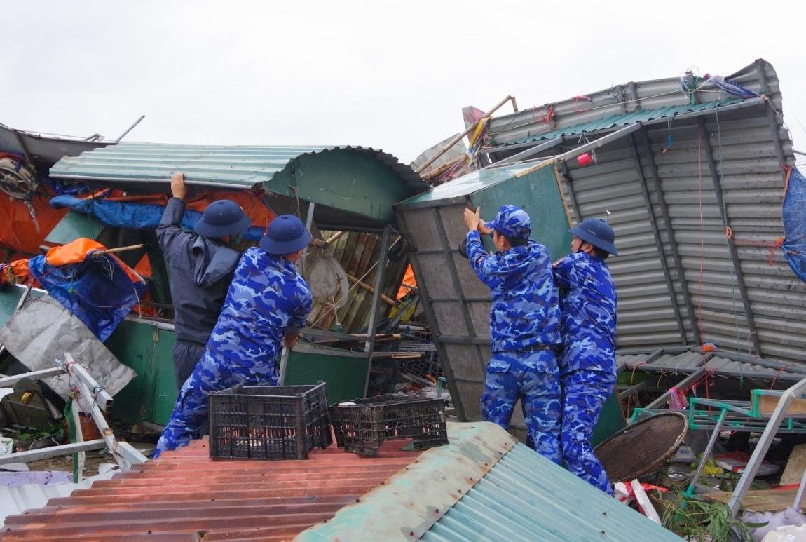 Lực lượng Cảnh sát biển giúp người dân tại thị trấn Cửa Việt sửa sang quầy hàng kinh doanh.