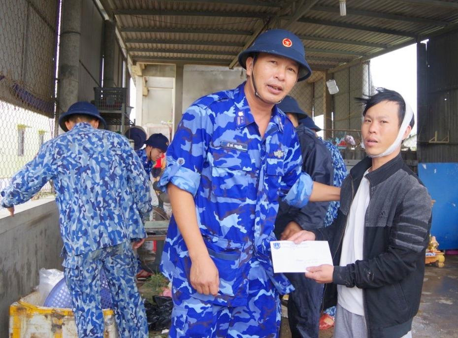 Trung tá Lê Bá Nguyên - Chính trị viên Hải đội 202 động viên, hỗ trợ người dân bị ảnh hưởng do thiên tai.