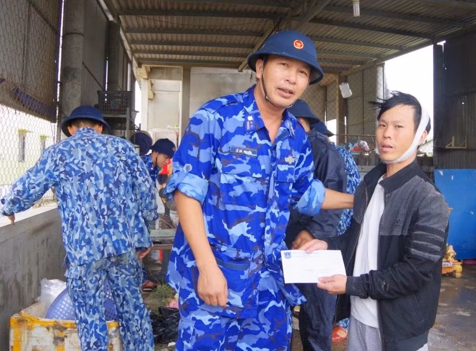 Trung tá Lê Bá Nguyên - Chính trị viên Hải đội 202 động viên, hỗ trợ người dân bị ảnh hưởng do thiên tai.