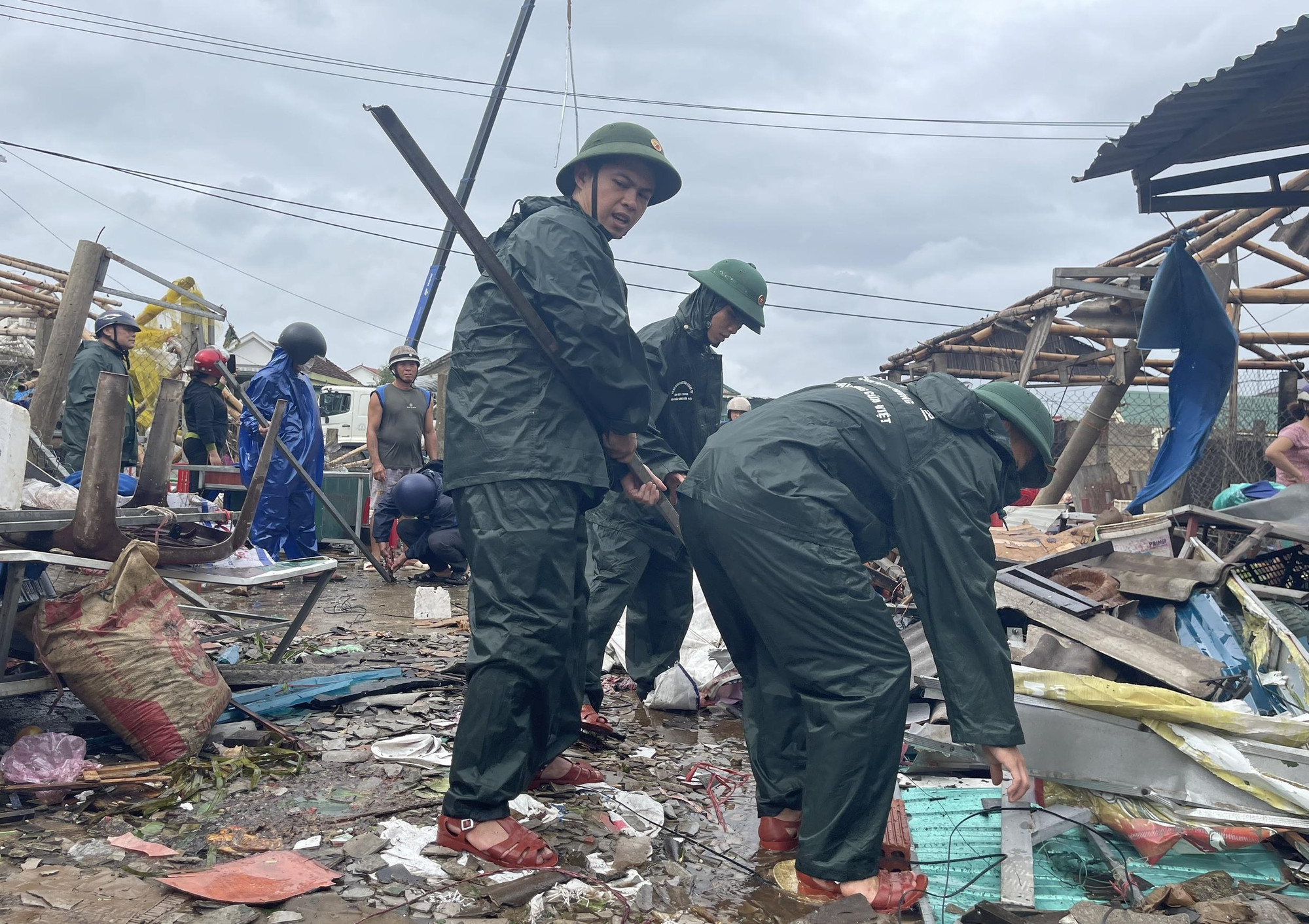 Các cán bộ, chiến sĩ thu gom các vật dụng sinh hoạt, vệ sinh đống đổ nát để người dân ổn định cuộc sống.