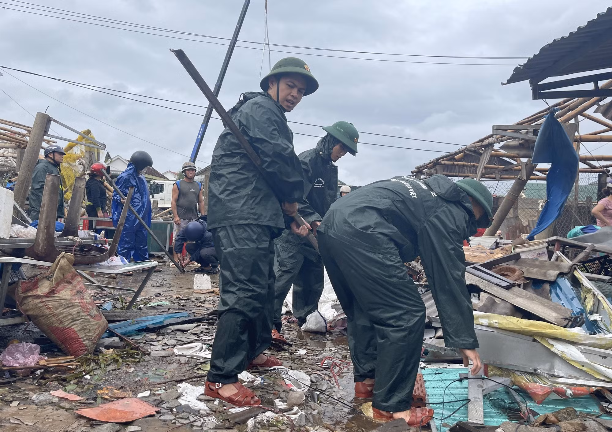 Các cán bộ, chiến sĩ thu gom các vật dụng sinh hoạt, vệ sinh đống đổ nát để người dân ổn định cuộc sống.