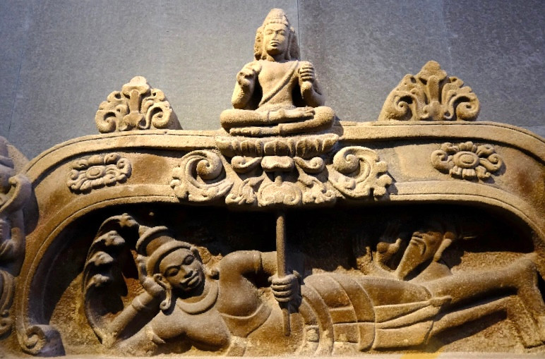 Trong nghệ thuật điêu khắc Ấn Độ, ở vị trí này thường là hình ảnh của nữ thần Lakshmi – vợ của Vishnu. Hai đầu bức phù điêu là hai chim thần Garuda mình người chân chim, hình tượng Garuda này rất phổ biến trong nghệ thuật Môn – Dvaravati ở Thái Lan. Trong nghệ thuật điêu khắc Ấn Độ, ở vị trí này thường là hình ảnh của nữ thần Lakshmi – vợ của Vishnu. Hai đầu bức phù điêu là hai chim thần Garuda mình người chân chim, hình tượng Garuda này rất phổ biến trong nghệ thuật Môn – Dvaravati ở Thái Lan.