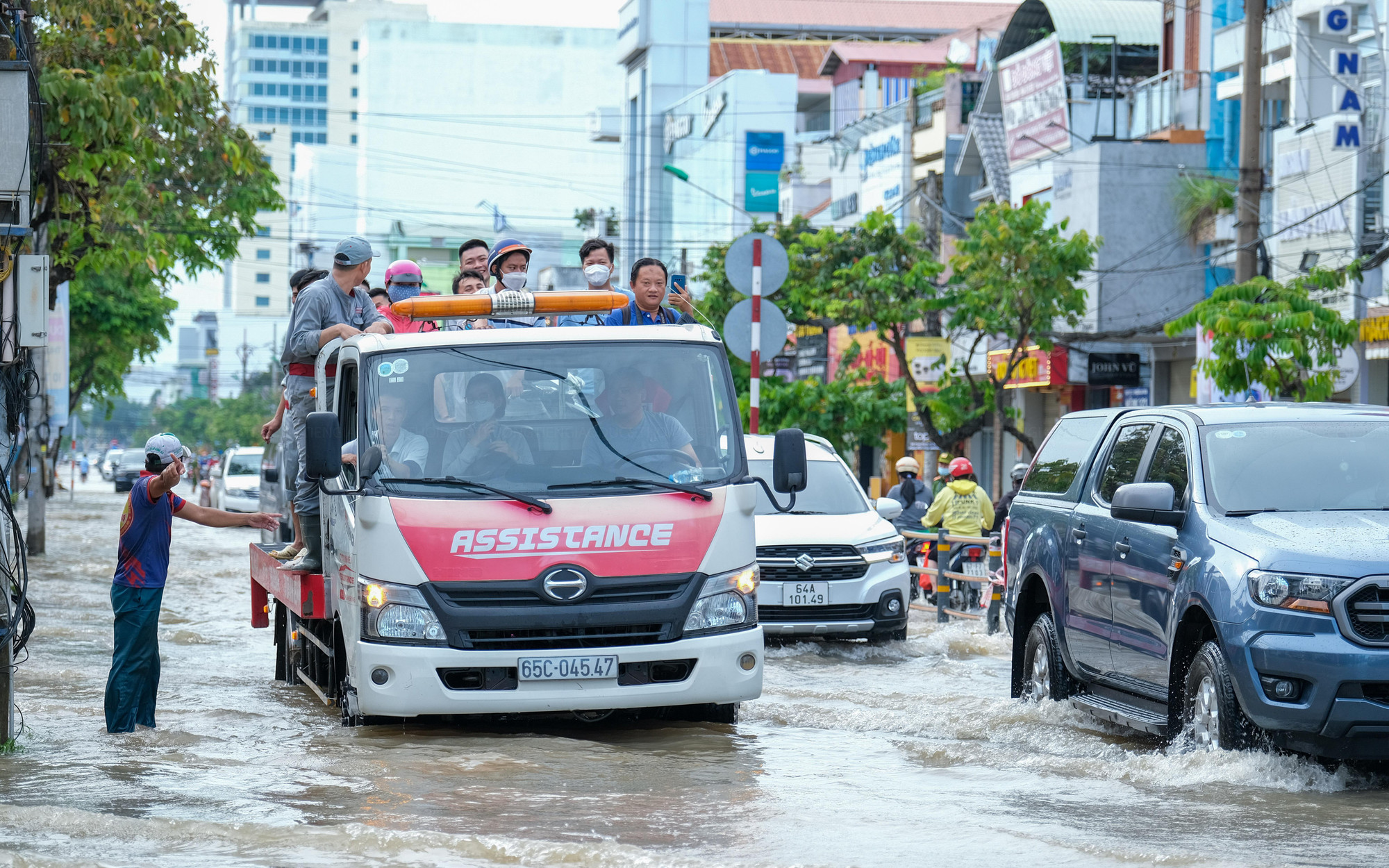 Xe dịch vụ cứu hộ được trưng dụng để hỗ trợ người dân có xe chết máy vượt qua vùng nước trũng.