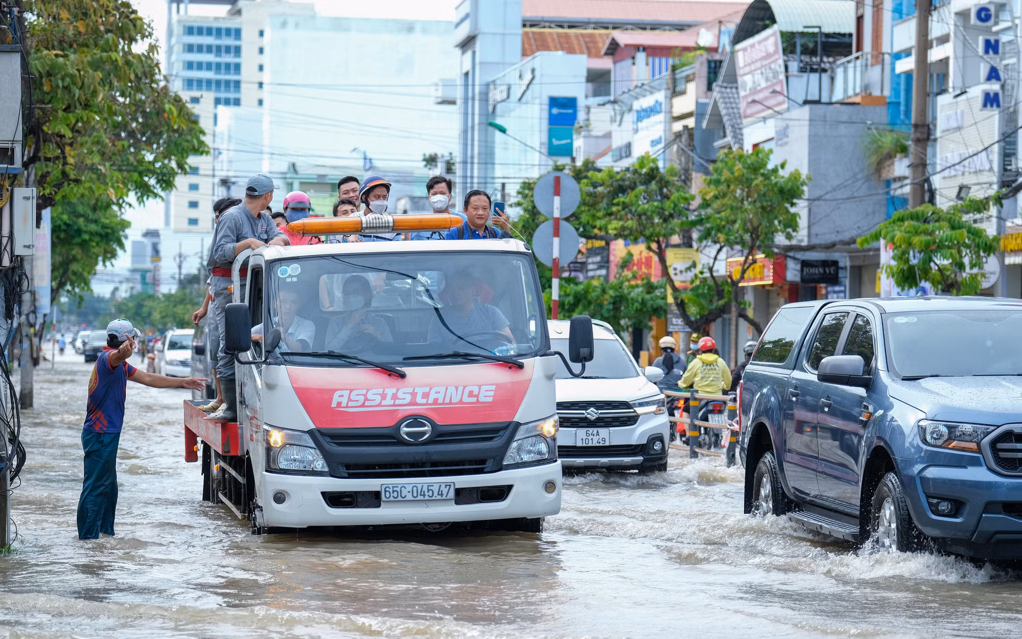 Xe dịch vụ cứu hộ được trưng dụng để hỗ trợ người dân có xe chết máy vượt qua vùng nước trũng.