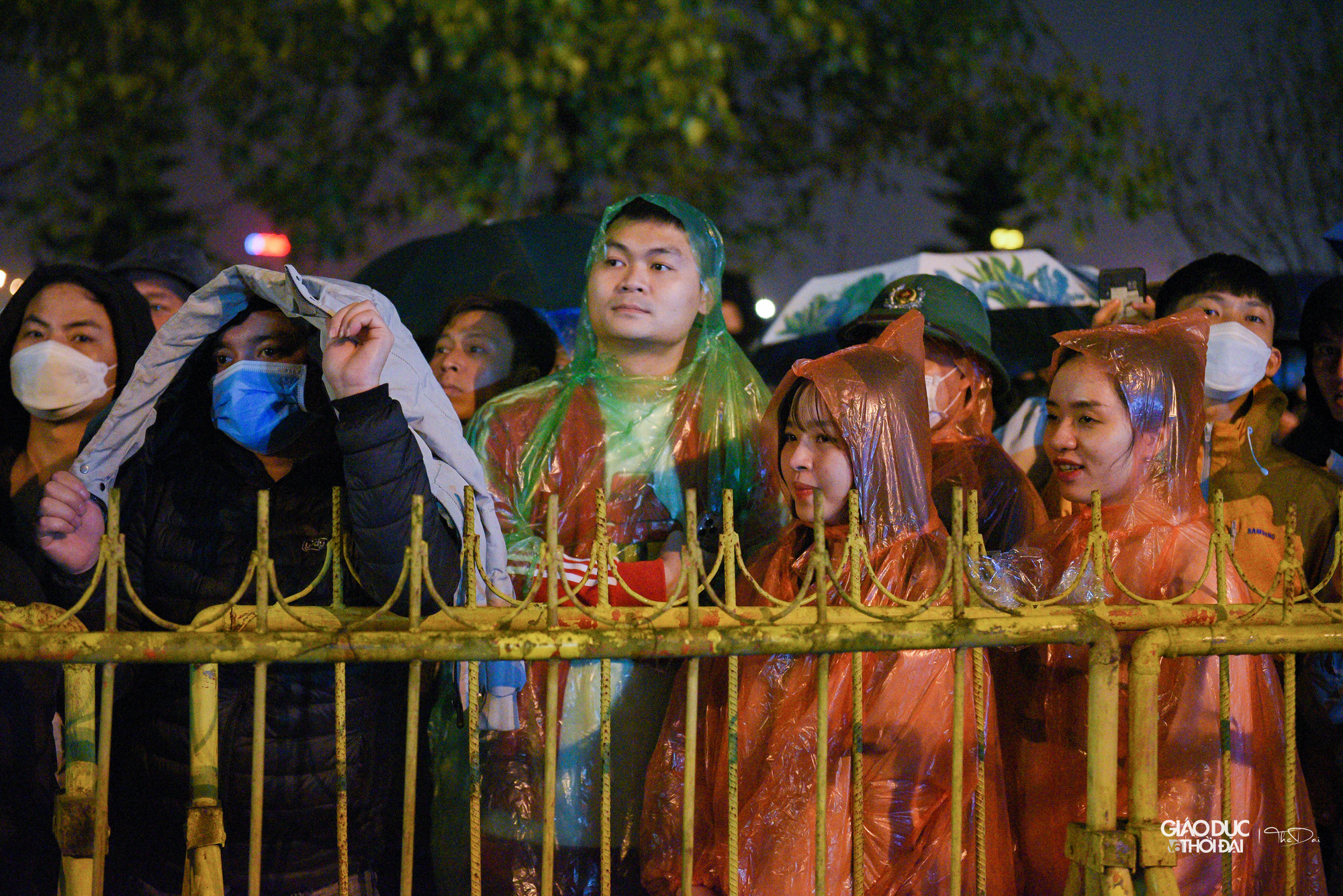 Trong buổi tối, nhiều lúc có mưa, người dân phải che ô, mặc áo mưa để đứng đợi. Trong buổi tối, nhiều lúc có mưa, người dân phải che ô, mặc áo mưa để đứng đợi.