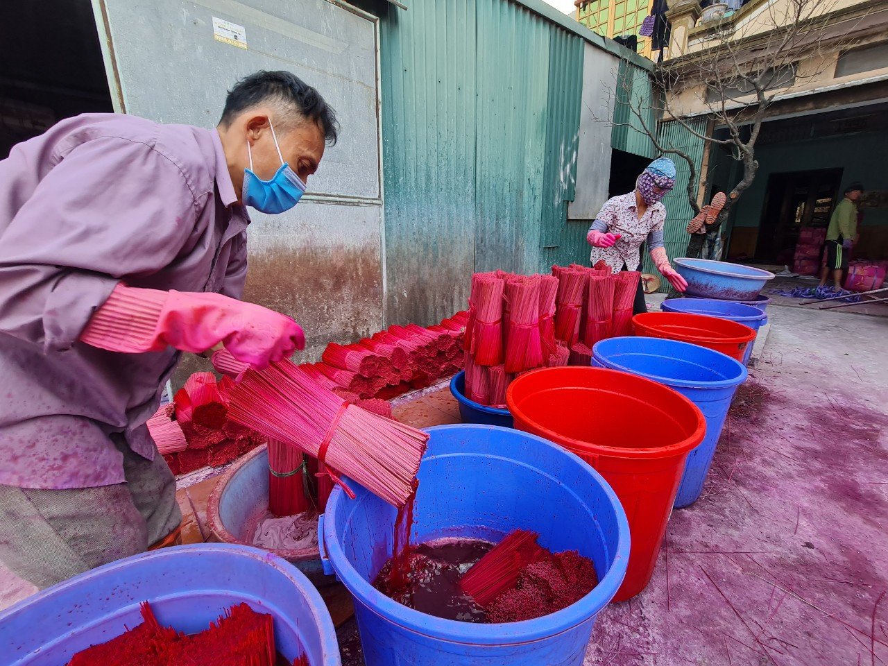 Dịp cuối năm, người dân Quảng Phú Cầu tất bật lao động, sản xuất để cho ra lò những mẻ hương mới, phục vụ nhu cầu của khách hàng. Theo người dân nơi đây, để hoàn thành một nén hương, người thợ phải làm nhiều công đoạn từ chẻ tre hoặc vầu, vót tăm, nhuộm chân hương, làm thân hương, phơi khô và đóng gói (trong ảnh là công đoạn nhuộm chân hương).