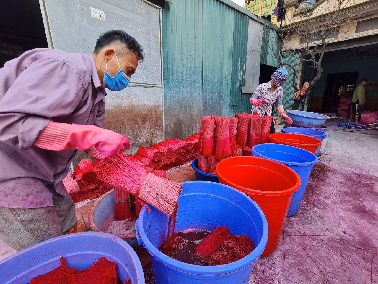 Dịp cuối năm, người dân Quảng Phú Cầu tất bật lao động, sản xuất để cho ra lò những mẻ hương mới, phục vụ nhu cầu của khách hàng. Theo người dân nơi đây, để hoàn thành một nén hương, người thợ phải làm nhiều công đoạn từ chẻ tre hoặc vầu, vót tăm, nhuộm chân hương, làm thân hương, phơi khô và đóng gói (trong ảnh là công đoạn nhuộm chân hương).